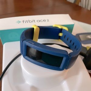 Ace 2 Fitbit kids activity tracker with blue and green silicone band and charger